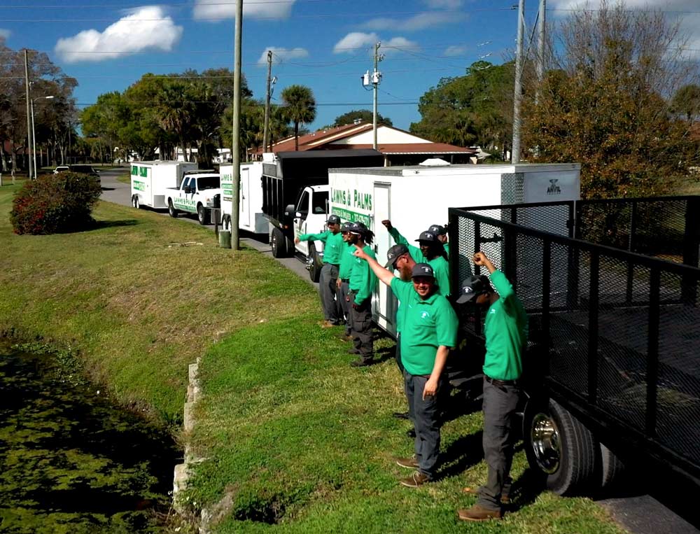 Large landscaping work team in front of company truck and trailer